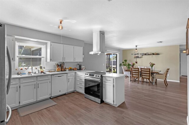 4727 Wales St, Lake Wales, FL 33859 - kitchen featuring appliances with stainless steel finishes, a sink, island exhaust hood, a peninsula, and light countertops
