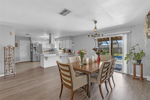 4727 Wales St, Lake Wales, FL 33859 - dining space featuring wood finished floors, baseboards, and a chandelier