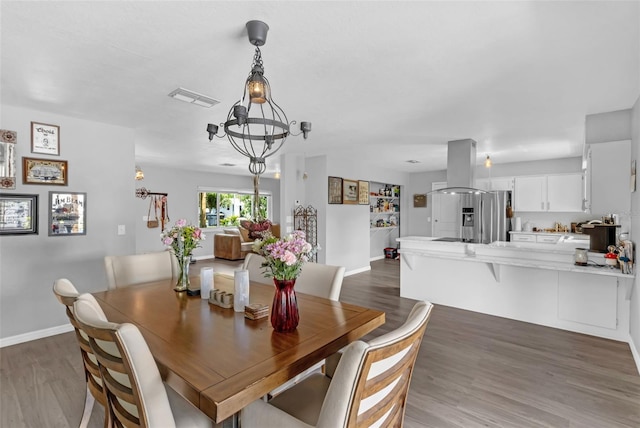 4727 Wales St, Lake Wales, FL 33859 - dining space with a chandelier, dark wood-style floors, and baseboards