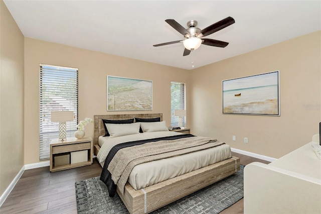 bedroom featuring baseboards, wood finished floors, and ceiling fan