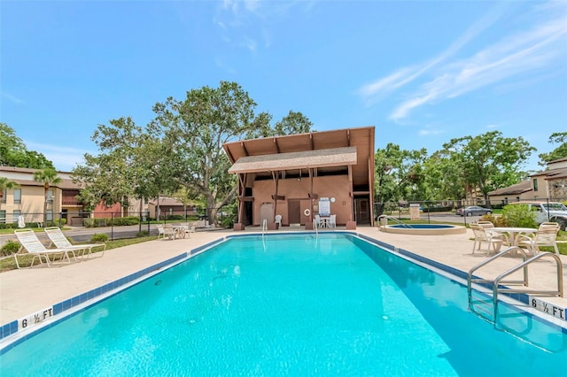 community pool featuring a patio and fence