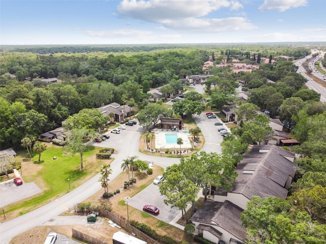 drone / aerial view of a heavily wooded area and a pool