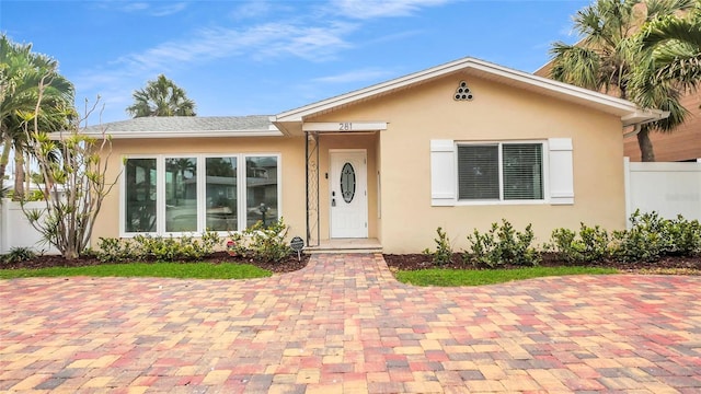 281 44th Ave, St Pete Beach, FL 33706 - view of front facade with stucco siding and fence