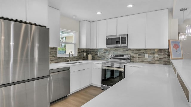 281 44th Ave, St Pete Beach, FL 33706 - kitchen featuring stainless steel appliances, a sink, light countertops, white cabinets, and recessed lighting