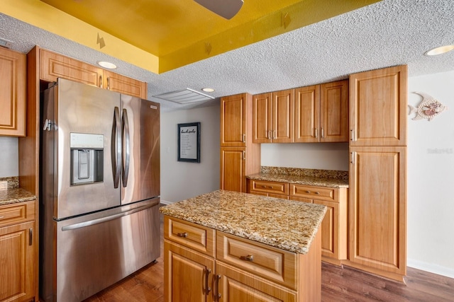 17408 Gulf Blvd Unit 203, Redington Shores, FL 33708 - kitchen featuring stainless steel fridge, dark wood-style floors, a center island, light stone countertops, and a textured ceiling