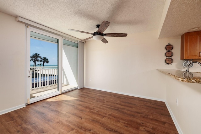 17408 Gulf Blvd Unit 203, Redington Shores, FL 33708 - empty room with a textured ceiling, wood finished floors, a ceiling fan, and baseboards