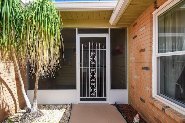 view of exterior entry with brick siding