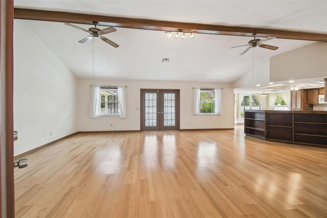 unfurnished living room featuring ceiling fan, beamed ceiling, light wood-style flooring, high vaulted ceiling, and baseboards
