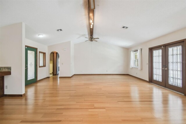 unfurnished living room with ceiling fan, arched walkways, light wood-type flooring, french doors, and baseboards