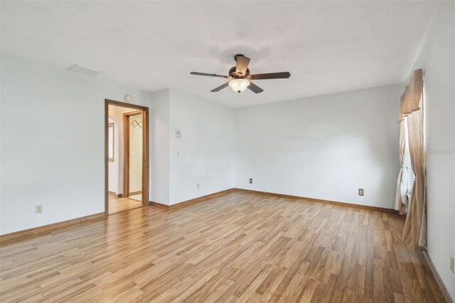 spare room featuring light wood-style flooring, ceiling fan, and baseboards
