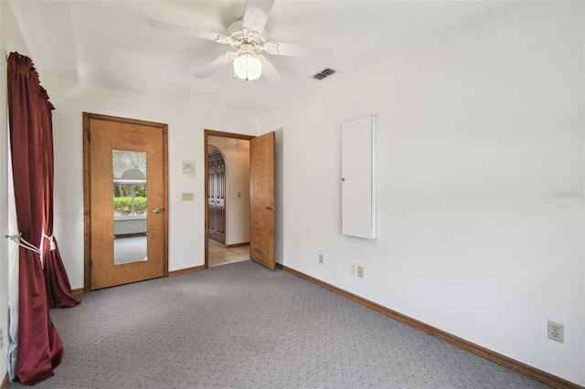 unfurnished bedroom with baseboards, carpet floors, and a ceiling fan