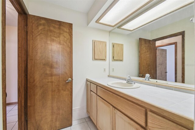 bathroom with tile patterned floors, vanity, and baseboards