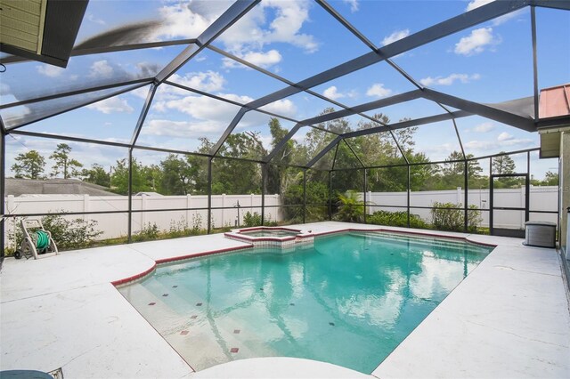 view of swimming pool with a pool with connected hot tub, a patio, a lanai, and a fenced backyard