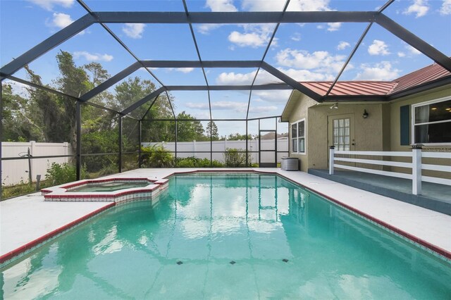 view of pool featuring a patio area, a pool with connected hot tub, fence, and glass enclosure