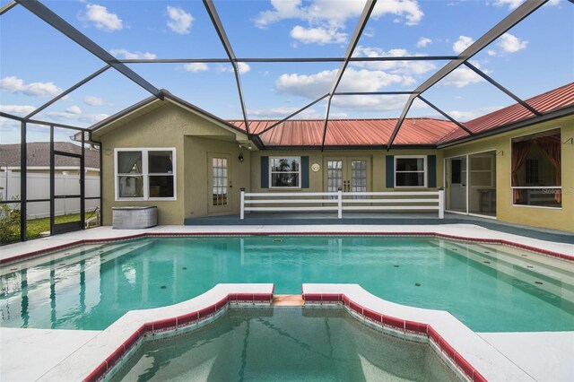 view of pool with a pool with connected hot tub, french doors, a patio, and a lanai