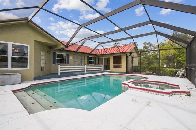 view of pool featuring a patio, a pool with connected hot tub, and a lanai