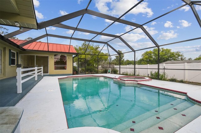 view of swimming pool featuring a patio area, a pool with connected hot tub, and a lanai