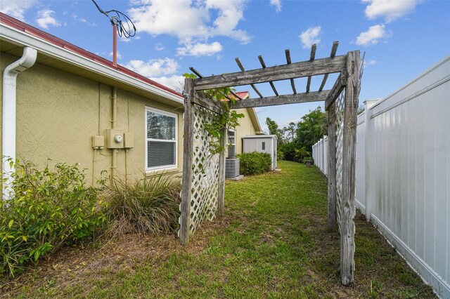 view of yard with central AC and a pergola