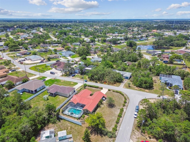 aerial perspective of suburban area with a pool area and a nearby body of water