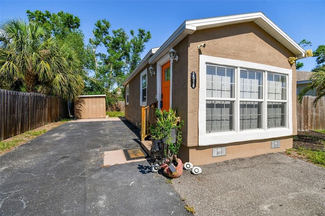 2018 21st St S, Saint Petersburg, FL 33712 - view of side of home featuring crawl space, fence, a patio, an outbuilding, and a storage shed