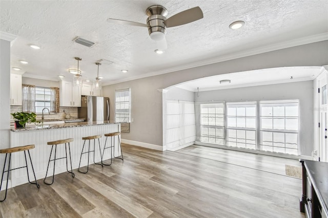 2018 21st St S, Saint Petersburg, FL 33712 - kitchen featuring freestanding refrigerator, a kitchen breakfast bar, light wood-style flooring, a ceiling fan, and baseboards