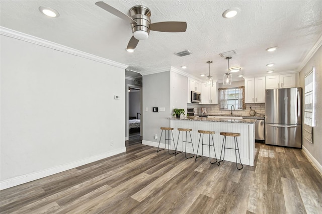 2018 21st St S, Saint Petersburg, FL 33712 - kitchen featuring stainless steel appliances, ceiling fan, a sink, a peninsula, and white cabinetry