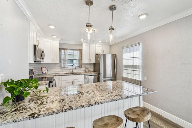 2018 21st St S, Saint Petersburg, FL 33712 - kitchen featuring stainless steel appliances, a sink, a peninsula, backsplash, and baseboards