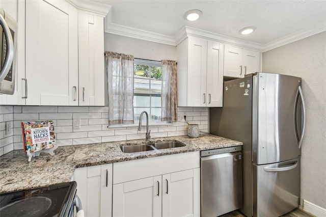2018 21st St S, Saint Petersburg, FL 33712 - kitchen featuring appliances with stainless steel finishes, a sink, crown molding, tasteful backsplash, and white cabinets