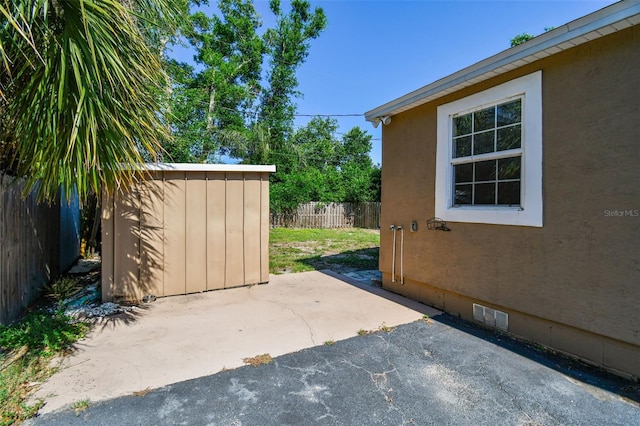 2018 21st St S, Saint Petersburg, FL 33712 - view of patio featuring a storage unit, a fenced backyard, and an outbuilding