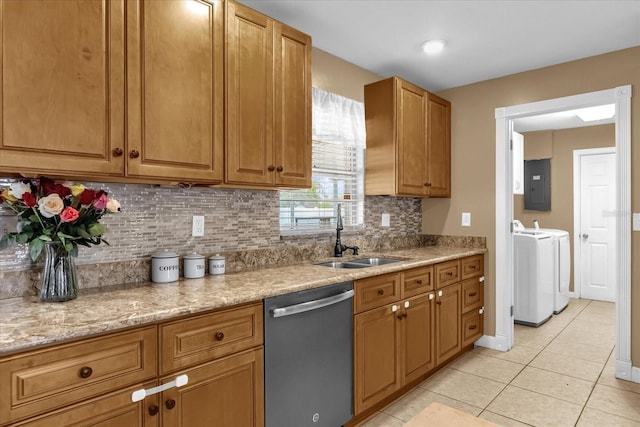 kitchen featuring stainless steel dishwasher, a sink, washer and clothes dryer, electric panel, and light tile patterned flooring