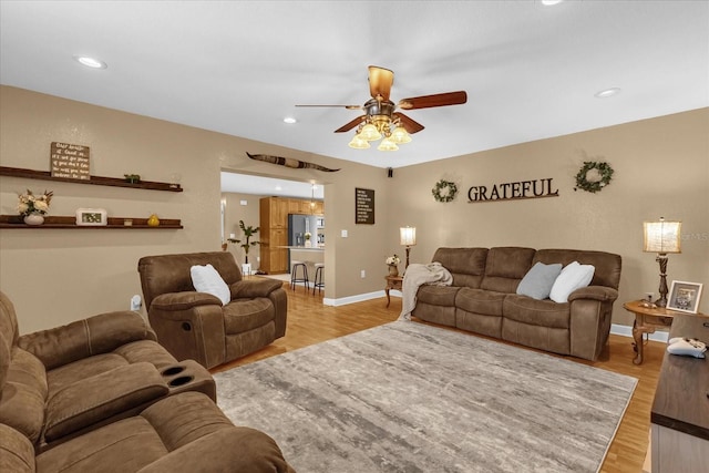 living area featuring a ceiling fan, light wood-style flooring, recessed lighting, and baseboards
