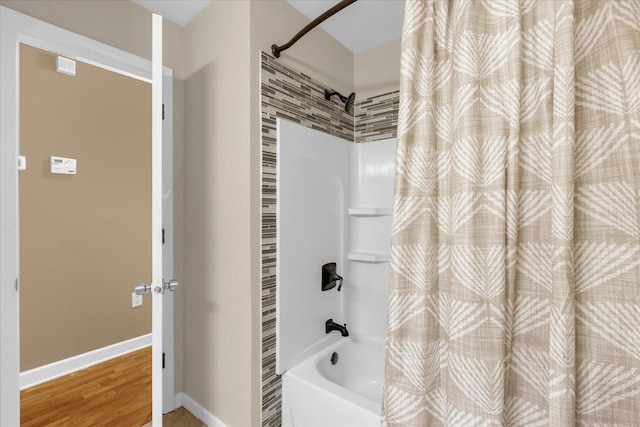 bathroom with shower / bath combination with curtain, baseboards, and wood finished floors