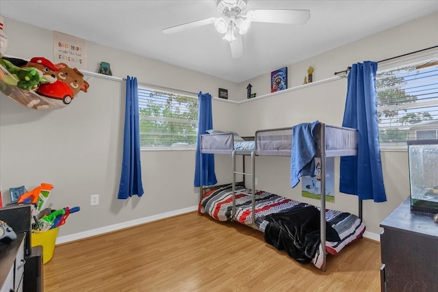 bedroom with wood finished floors, baseboards, and a ceiling fan