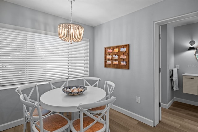 608 Betmor Ln, Palm Harbor, FL 34683 - dining space featuring a chandelier, wood finished floors, and baseboards