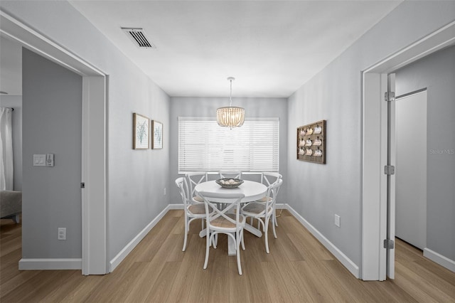 608 Betmor Ln, Palm Harbor, FL 34683 - dining space featuring light wood-style floors, baseboards, and a chandelier
