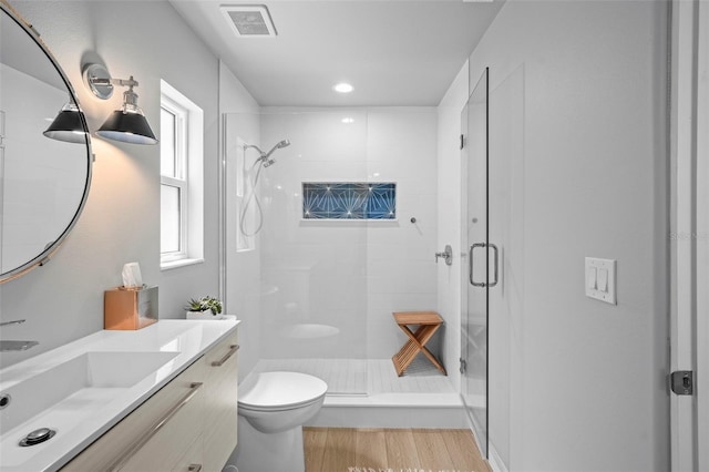 608 Betmor Ln, Palm Harbor, FL 34683 - bathroom with a shower stall, toilet, vanity, wood finished floors, and recessed lighting