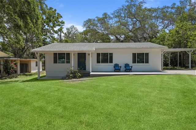 608 Betmor Ln, Palm Harbor, FL 34683 - back of house with a yard, an attached carport, and roof with shingles