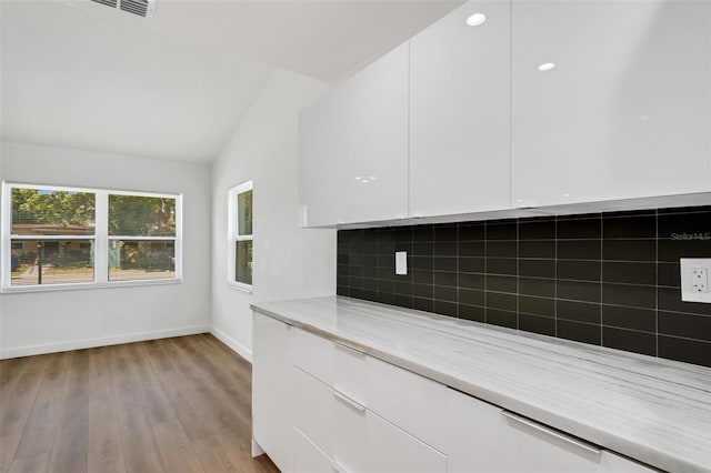 3151 6th Ave S, Saint Petersburg, FL 33712 - kitchen featuring white cabinets, modern cabinets, baseboards, tasteful backsplash, and vaulted ceiling