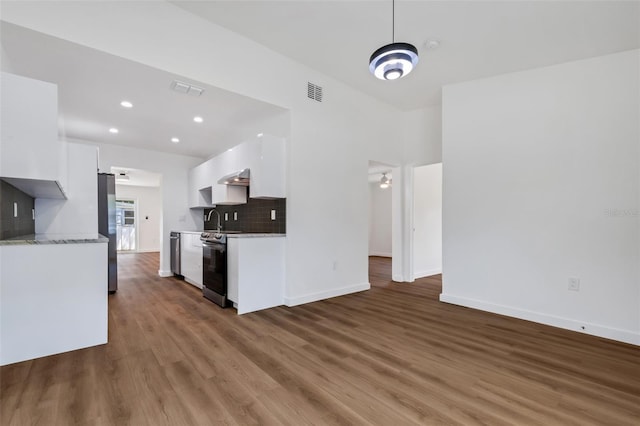 3151 6th Ave S, Saint Petersburg, FL 33712 - kitchen featuring stainless steel appliances, white cabinetry, wood finished floors, a sink, and backsplash