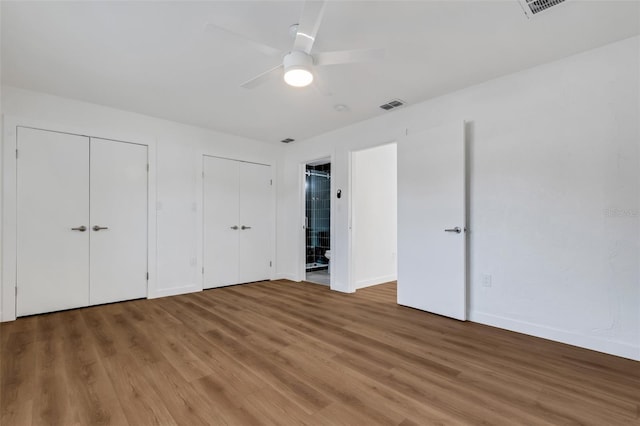 3151 6th Ave S, Saint Petersburg, FL 33712 - unfurnished bedroom with two closets, light wood-style floors, baseboards, and a ceiling fan