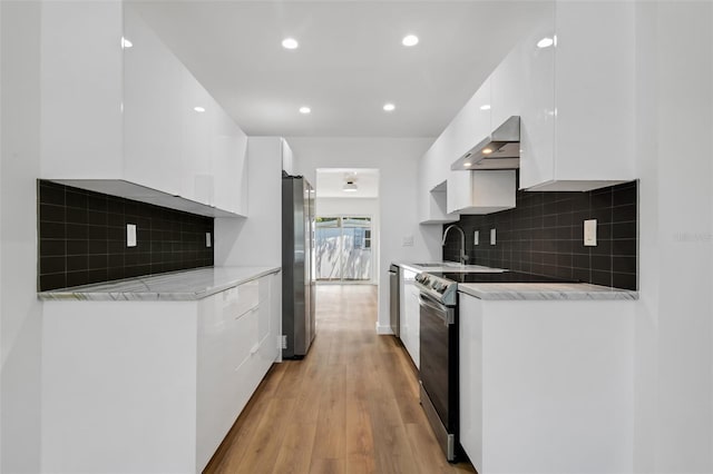 3151 6th Ave S, Saint Petersburg, FL 33712 - kitchen with modern cabinets, appliances with stainless steel finishes, white cabinets, wall chimney range hood, and recessed lighting
