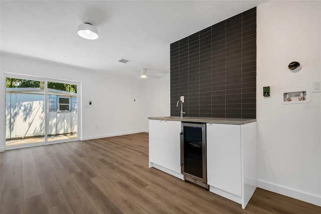 3151 6th Ave S, Saint Petersburg, FL 33712 - indoor wet bar with beverage cooler, wood finished floors, baseboards, a ceiling fan, and decorative backsplash