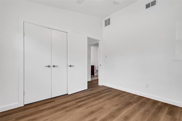 3151 6th Ave S, Saint Petersburg, FL 33712 - unfurnished bedroom with wood finished floors, a closet, and baseboards