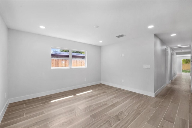 spare room with light wood-style floors, baseboards, and recessed lighting