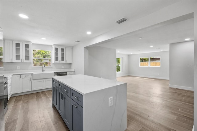 kitchen featuring a sink, white cabinetry, recessed lighting, light wood-style flooring, and dishwasher