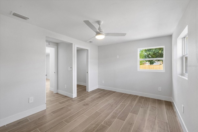 empty room with wood finished floors, ceiling fan, and baseboards