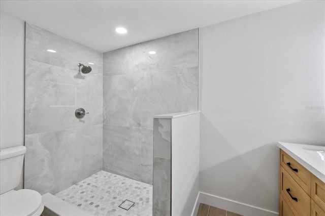 full bath featuring tiled shower, toilet, and vanity
