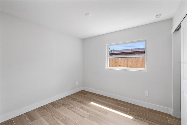 unfurnished room featuring wood finished floors and baseboards