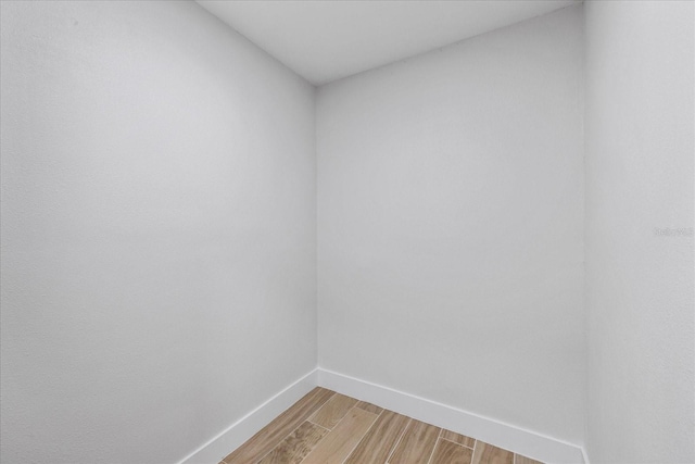 unfurnished room with baseboards and light wood-style flooring