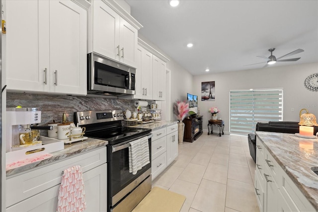 19212 Sunlake Blvd, Lutz, FL 33558 - kitchen featuring stainless steel appliances, tasteful backsplash, a ceiling fan, white cabinets, and light tile patterned floors